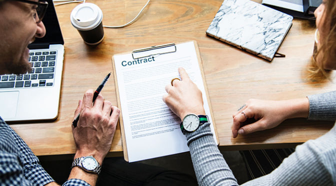 A couple signing a contract for their next home